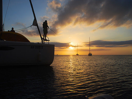 Persona pescando al atardecer a bordo de un catamaran en Ibiza